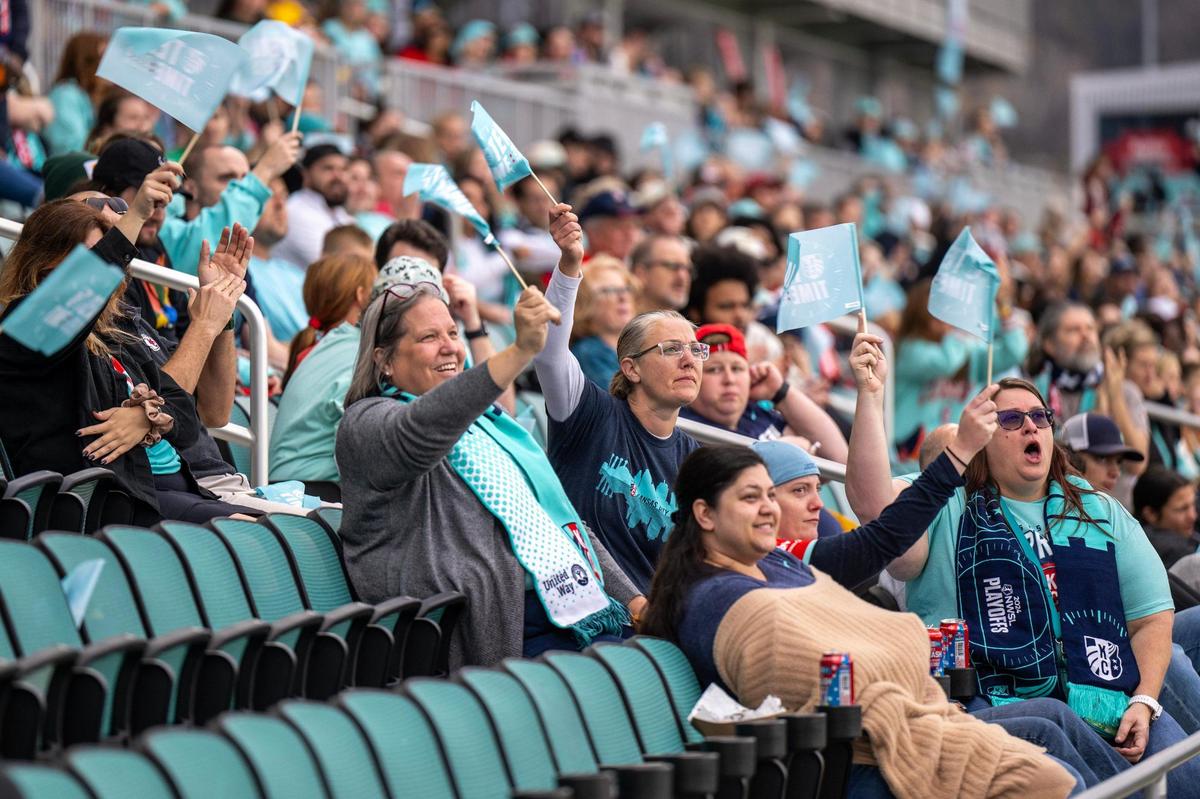 Fans wave miniature KC Current flags and cheer during a watch party at CPKC Stadium for the semifinal match against the Orlando Pride on Sunday, Nov. 17, 2024, in Kansas City.