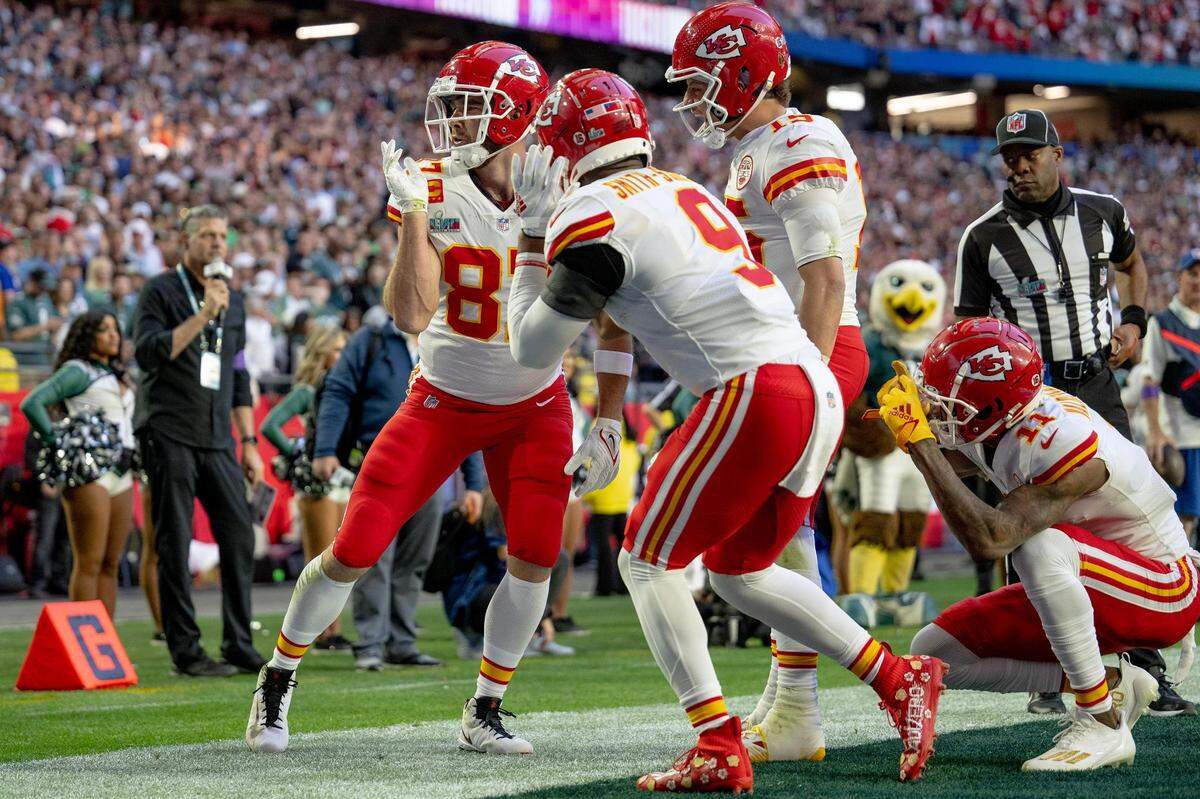 Chiefs quarterback Patrick Mahomes (15), joins in on the celebration and watches Kelce dance while Marquez Valdes-Scantling (11) squats down and pretends to take photos of the performance.