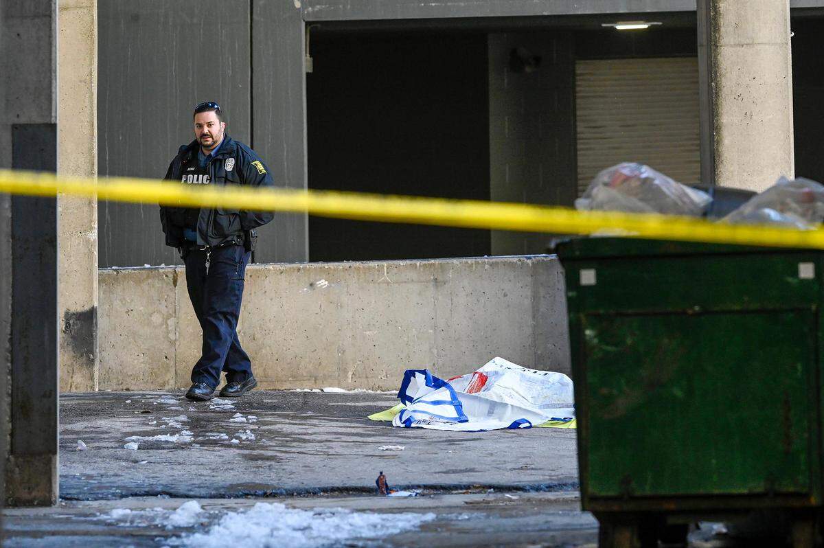 A Kansas City police officer walks in an alley near 10th Street and Grand Boulevard where the body of child believed to be under 12-year-old was found dead on Monday, Nov. 27, 2023, in downtown Kansas City. The police are investigating the incident as a suspicious death.