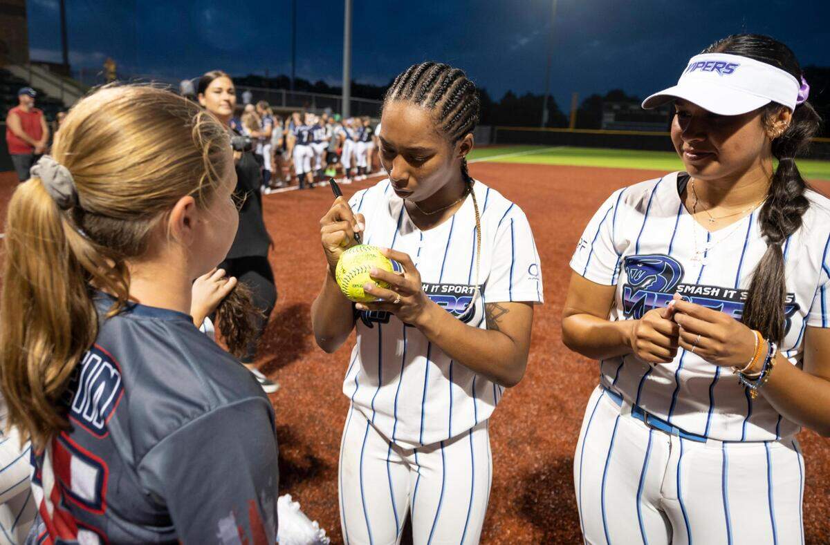 Vipers outfielder Ciara Bryan signs a young fan’s ball after the USSSA Pride took on the Smash It Vipers in the inaugural opening day game for the WPF in at the Shawnee Mission Softball Complex on Tuesday, June 14, 2022.