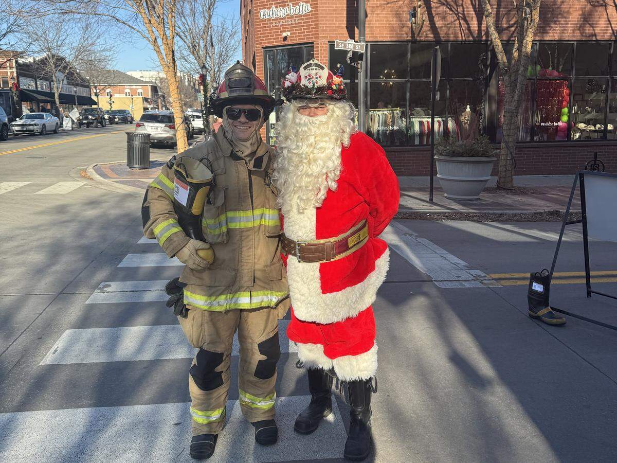 Firefighter Connor Eller and Santa Claus greet visitors to downtown Lee’s Summit during the annual Boot Block fundraiser.