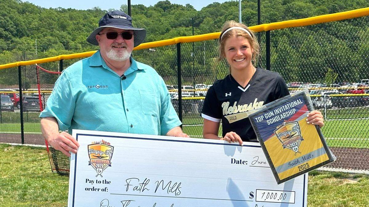 Top Gun Invitational founder Robb Behymer and scholarship winner Faith Mills of Nebraska Gold 18u hold up her award at the softball tournament in the KC-area on June 15, 2023.