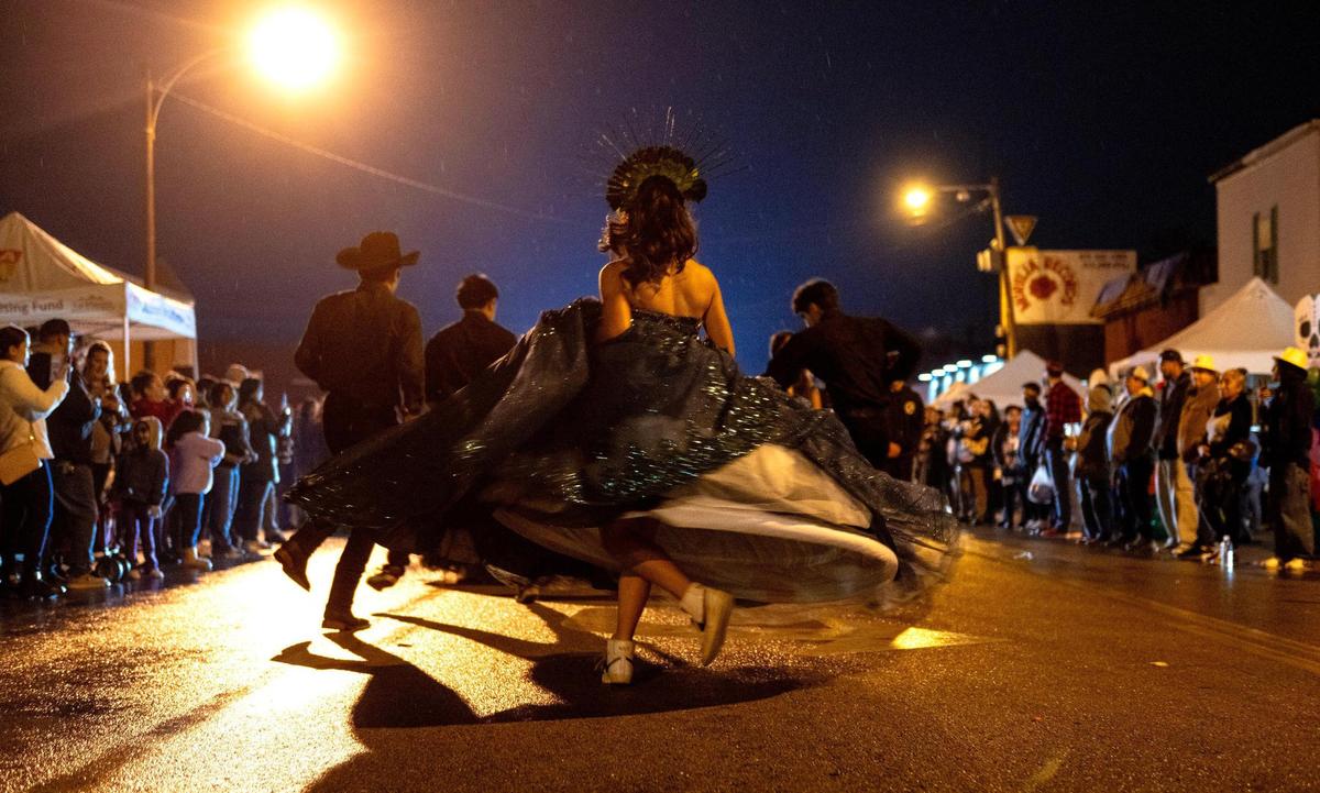 Members of Baila KC perform during the Dia de los Muertos parade hosted by the Central Avenue Betterment Association on Saturday in Kansas City, Kan.