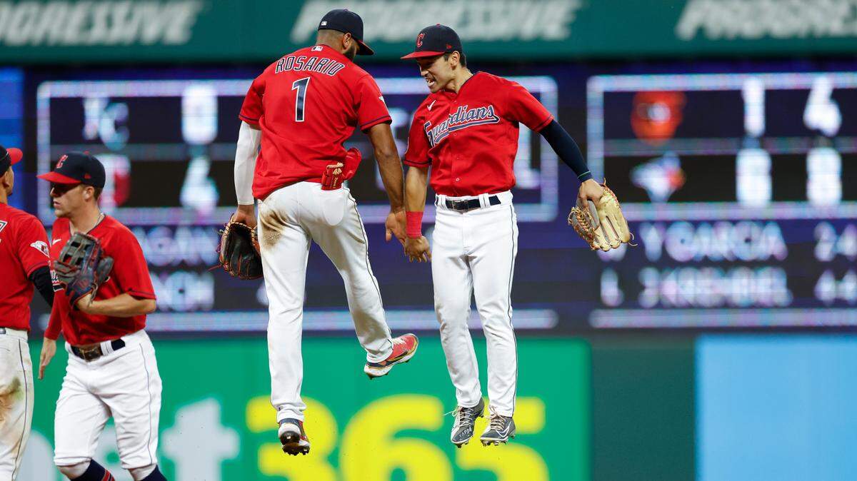 Cleveland Guardians shortstop Amed Rosario (1) and left fielder Steven Kwan celebrate an 8-4 win against the Detroit Tigers in a baseball game Wednesday, Aug. 17, 2022, in Cleveland. (AP Photo/Ron Schwane)