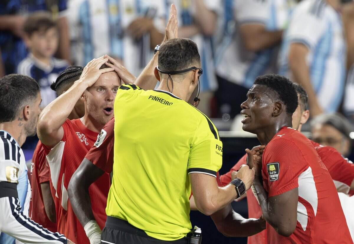 Switzerland forward Breel Embolo, right, pleads his case with the referee after picking up his second yellow card against Argentina during the FIFA World Cup quarterfinal match at Kansas City (Arrowhead) Stadium in Kansas City on Saturday, July 11, 2026.