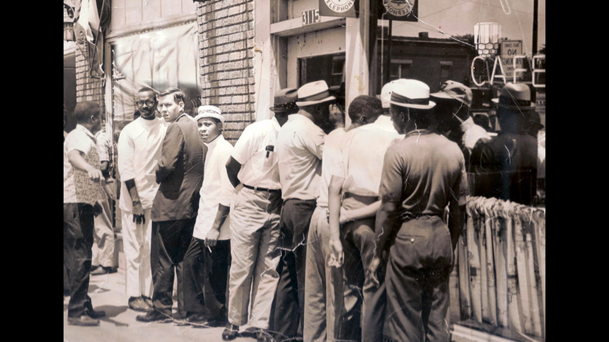 Charles Hammer (wearing a dark suit coat), reported for the Star on a 1963 stand-in by Black patrons denied entrance in their own neighborhood to the Pete Karos Cafe at 3115 Prospect Ave.