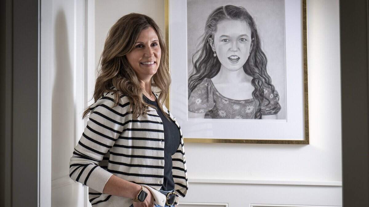 Sara Bloomfield stands with a portrait of her daughter, Olivia, at her home in Leawood, Kansas, on Wednesday, April 1, 2026. Olivia, who was born with and lived with Congenital Muscular Dystrophy, was a champion for accessibility and inclusion in playgrounds and bathrooms across Kansas City. Through her foundation, the Olivia Bloomfield Foundation, Sara continues the work they started together, honoring Olivia's legacy.