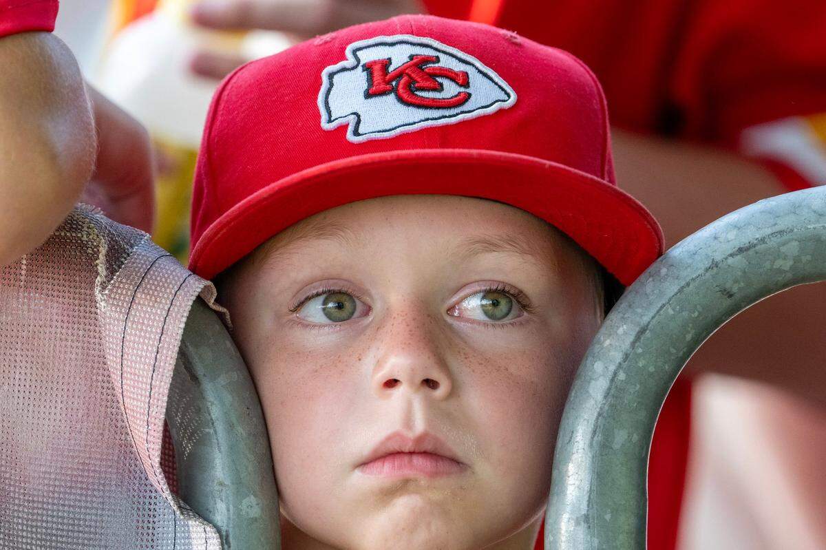 Five-year-old Boyd Nielsen peeks between barricades to watch players walk to the field for practice at Chiefs training camp in St. Joseph.