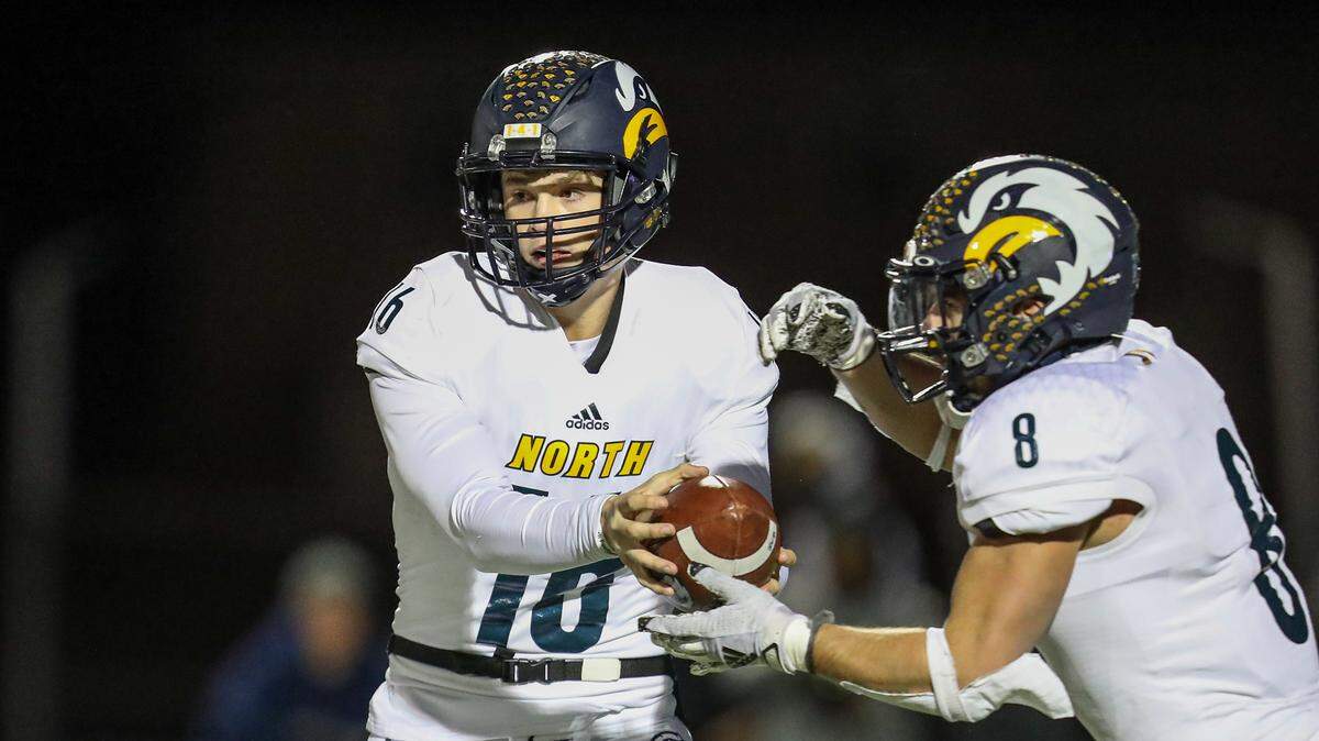 Liberty North’s Sam Van Dyne (16) hands off to Liberty North’s Cayden Arzola (8) during the second quarter of the Class 6, District 4 championship game with Park Hill South on November 12, 2021, in Kansas City, MO.