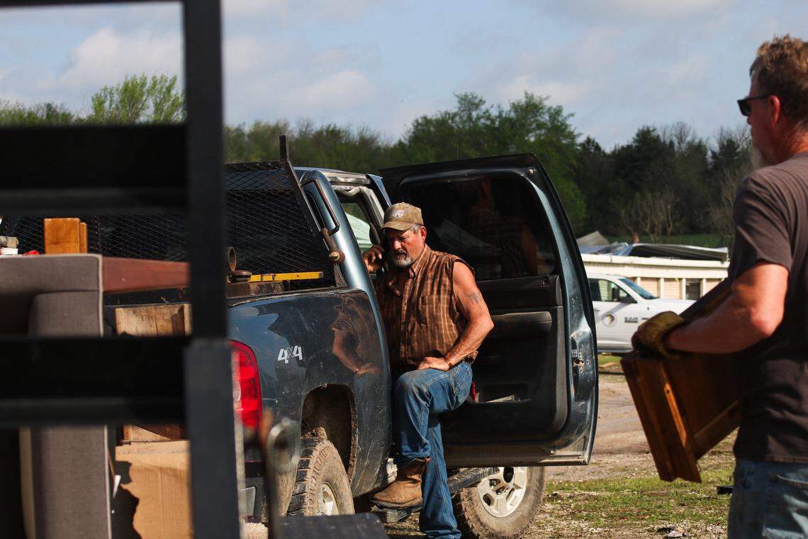 Douglas Clement, 58, talks on the phone while he searches through a destroyed storage building for his boss’ daughter at Hillsdale Boat & Mini Storage on April 14, 2026. A tornado caused widespread damage in the area, completely destroying most of the storage unit buildings on the property.