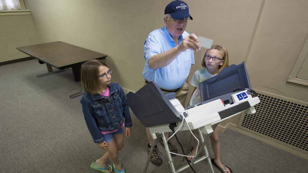 John Miller of Kansas City used casting his ballot as a civics lesson for his granddaughters Grace Albers (left), 9, and Anna Albers, 10, both of Merriam as he voted Tuesday at Wornall Road Baptist Church, 400 W. Meyer Blvd. Kansas City residents went to the polls to elect a mayor and City Council.