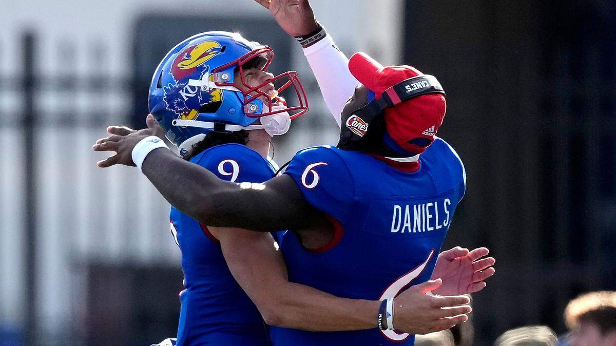 Injured Kansas quarterback Jalon Daniels, right, celebrates with starting quarterback Jason Bean during the Jayhawks’ 37-16 victory over Oklahoma State in Lawrence.