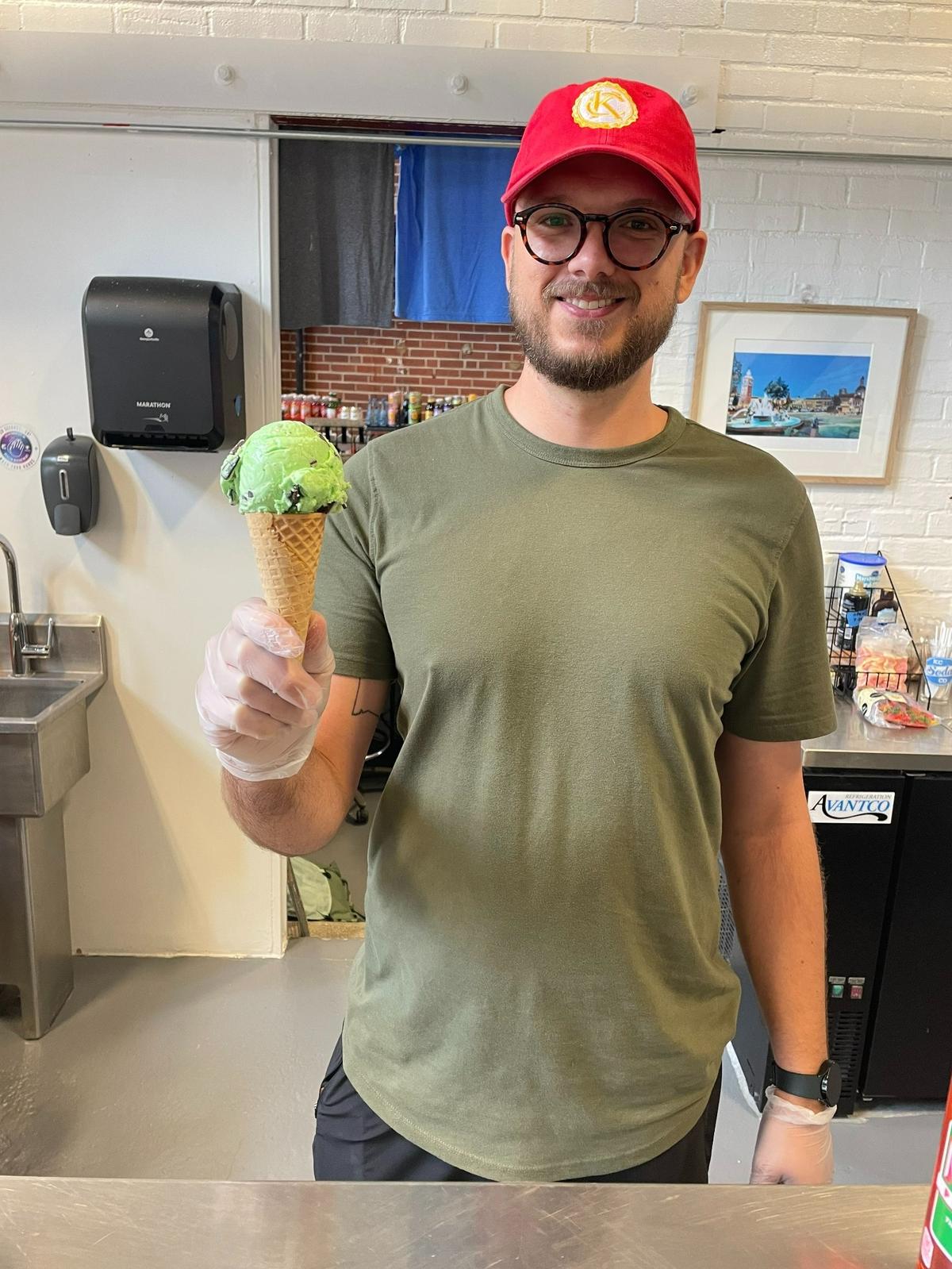 Fountain City Scoops and Floats manager Cale Fichter holds a freshly scooped mint chocolate chip waffle cone.