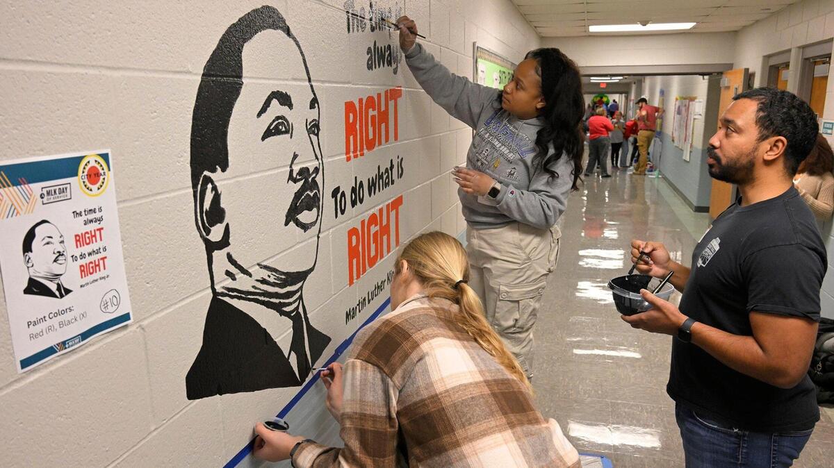 Volunteers Lauren Baratta, from left, Matt Oates, and Keyera Collins, employees of Burns & McDonnell, painted a mural of Martin Luther King Jr., during MLK Day of Service in 2024 at Pitcher Elementary School.