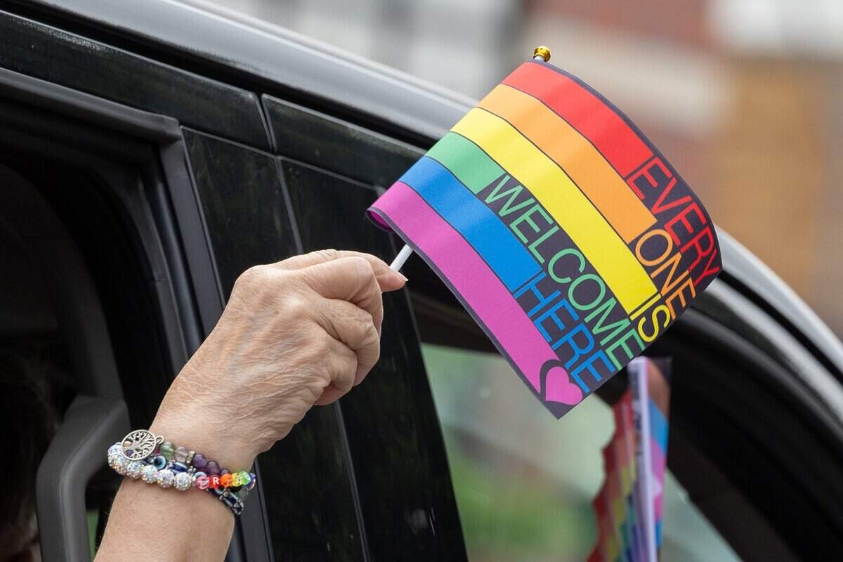 Parade attendee holds a flag out the window of their car during Kansas City's Annual Pride Parade  at Westport Rd on Saturday, June 6, 2026.