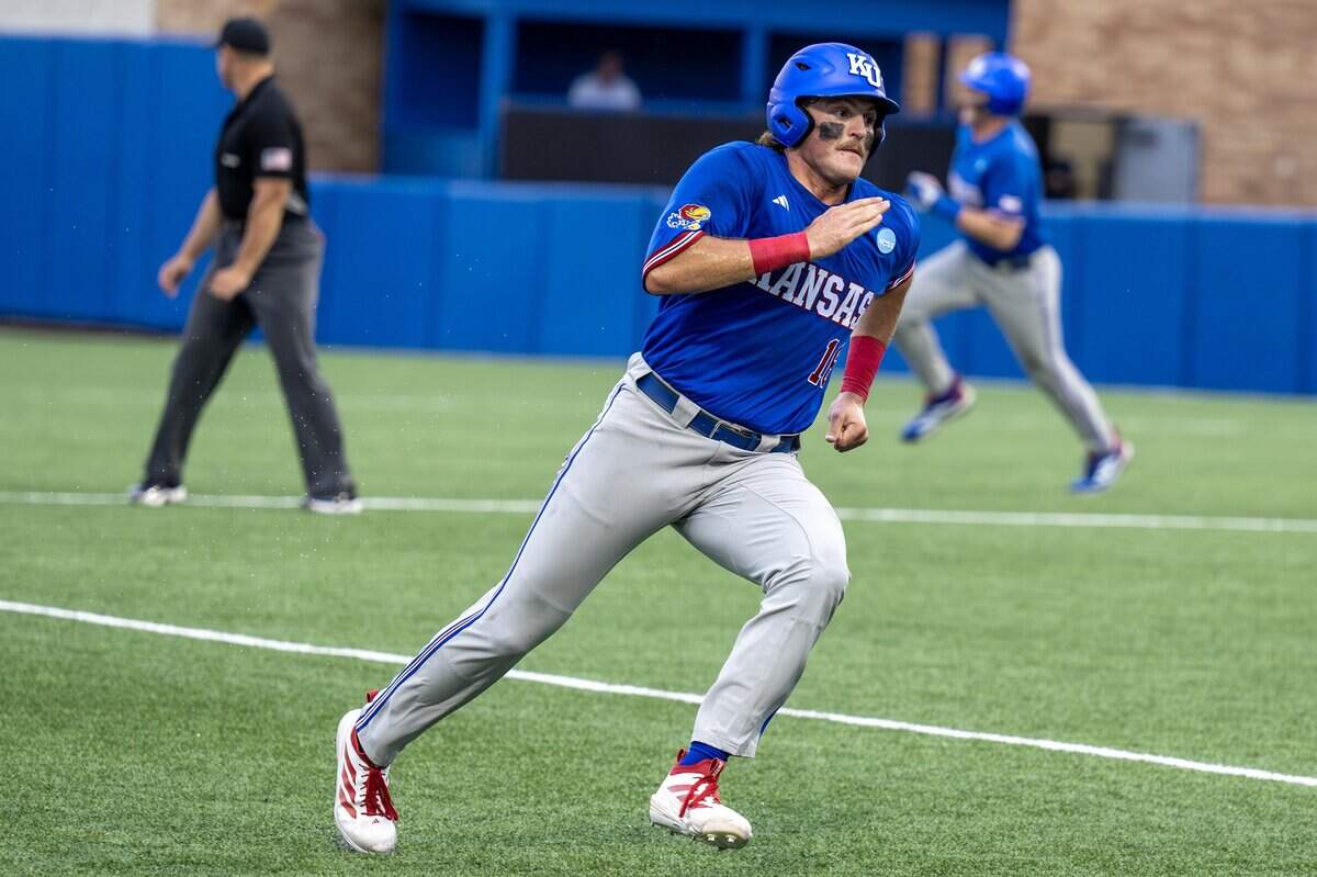 Kansas Jayhawks infielder Josh Dykhoff (16) advances to third base after teammate Jordan Bach (31) hit an RBI single in the second inning of an NCAA Super Regional baseball game against Oklahoma at Hoglund Ballpark on Sunday, June 7, 2026, in Lawrence.