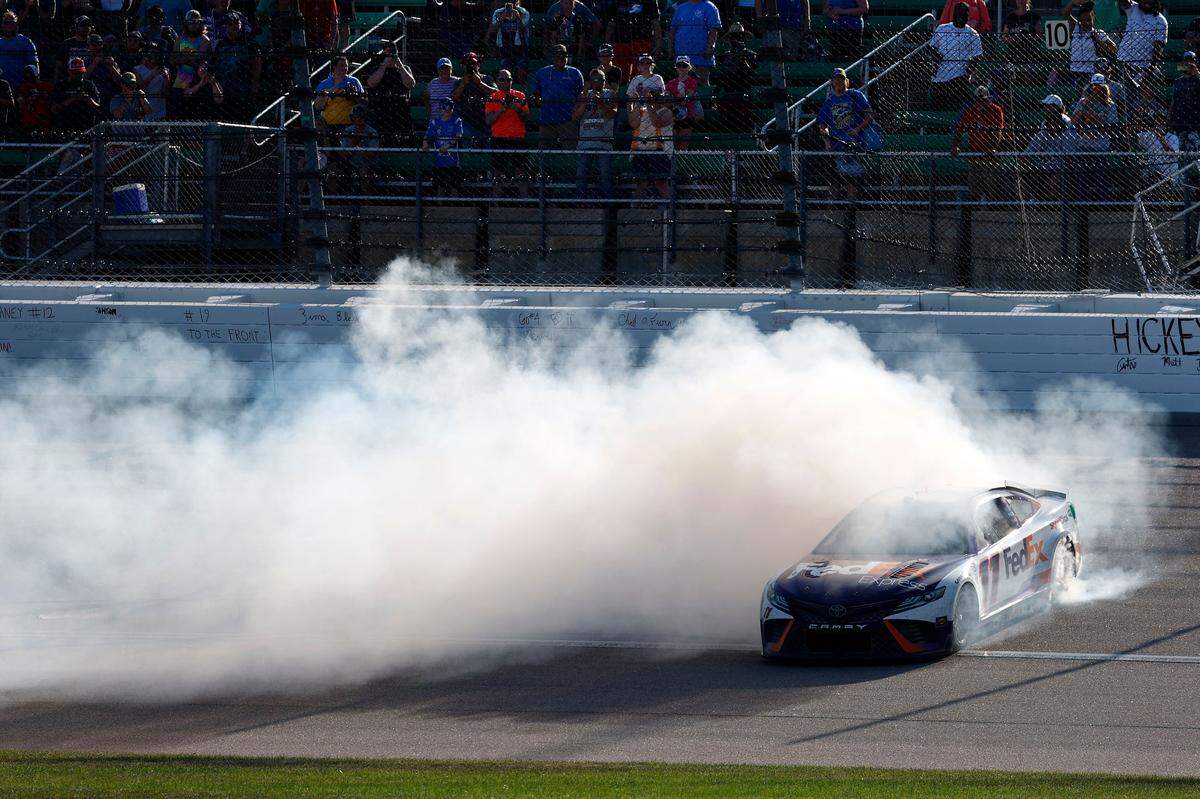 NASCAR Cup driver Denny Hamlin treats spectators to the traditional winner’s smokeshow after prevailing in Sunday’s AdventHealth 400 race at Kansas Speedway in Kansas City, Kan.