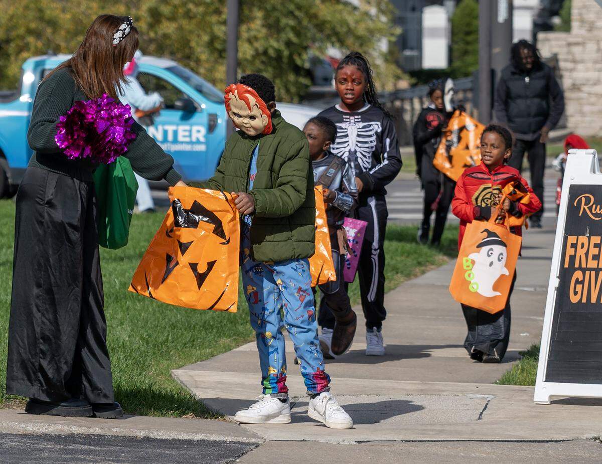 Children in costumes receive candy from Russell Stover employees during the company's annual Halloween giveaway at the company's headquarters on Friday, Oct. 31, 2025, in Kansas City.