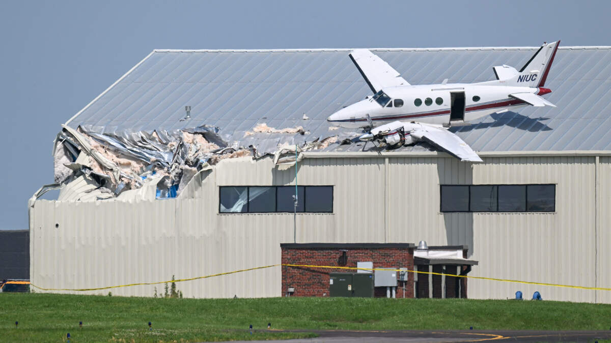 A Beechcraft airplane rests on the roof of a building at New Century AirCenter after it made a crash landing that left it on the roof on Monday, June 16, 2025.