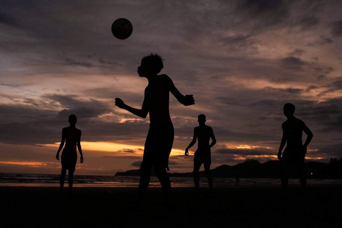 Children play soccer on the shore of Jose Menino Beach as the sun sets on Christmas Day in Santos, Brazil.