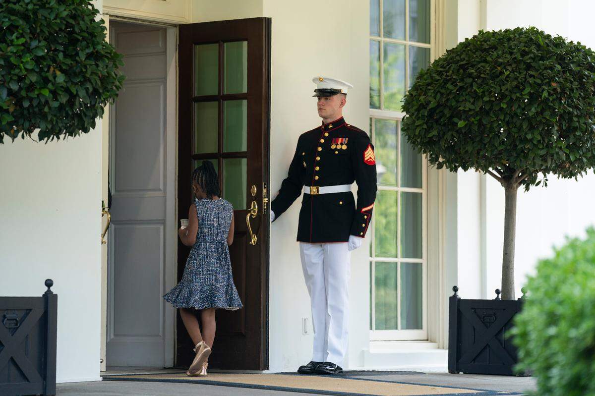 A Marine holds the door as Gianna Floyd, the daughter of George Floyd, walks into the White House, Tuesday, May 25, 2021, in Washington.