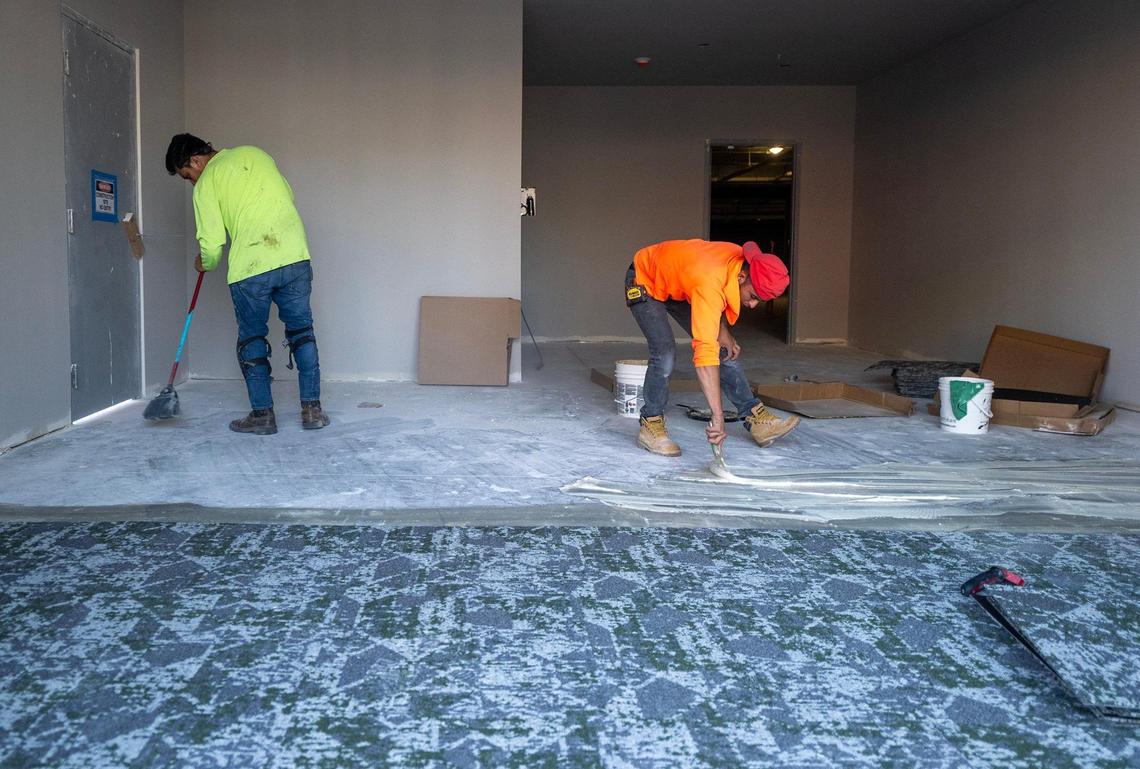 Workers lay carpet inside Katz on Main at Main Street and Westport Road.
