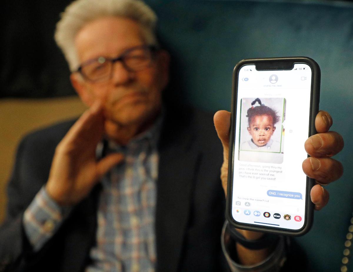 Bob Hopkins shows a photo of Shawntel Anderson around age 1, which he said is the oldest photo Anderson remembers having of herself. Hopkins and his partner Bob Whisnant found Anderson when she was about eight months old on the back porch of a home during a snow storm in Kansas City in 1982. They met Saturday in Dallas.