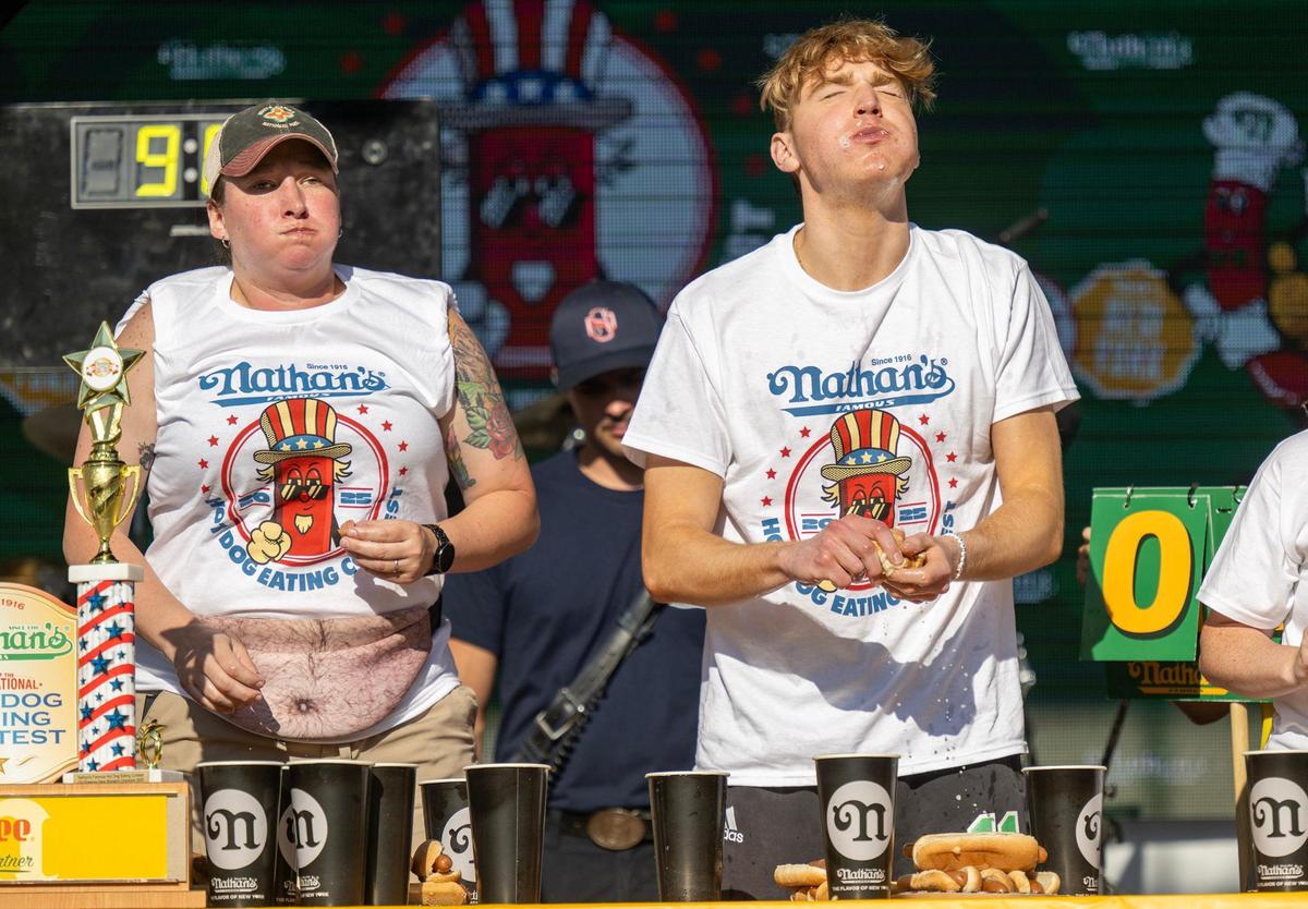 Jocelyn Young, left, of Sherman, Texas, and Cameron Meade of Valparaiso, Indiana, ate hot dogs during Nathan’s Famous Hot Dog Eating Contest at Old Shawnee Days on Saturday, June 7, 2025, in Shawnee. Meade ate 25, while Young ate 11.5 hot dogs.