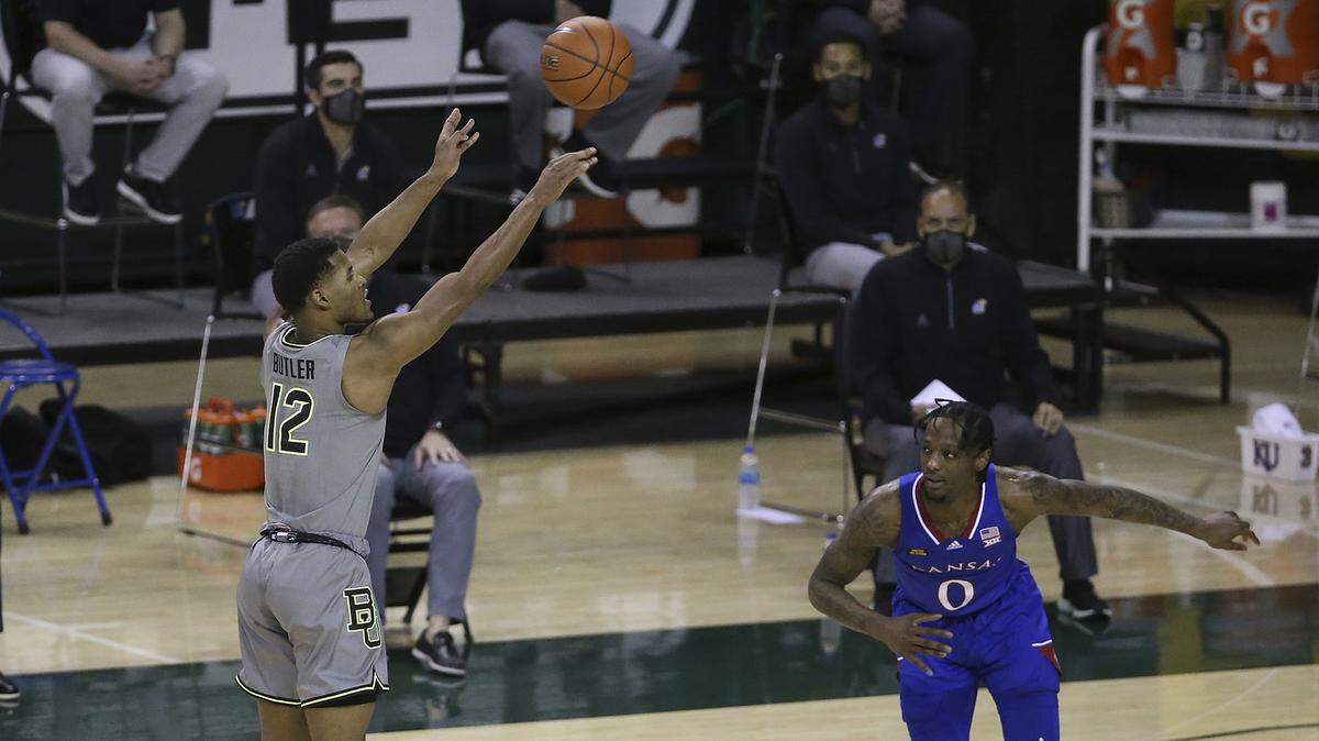 Baylor guard Jared Butler (12) shoots a three-point basket past Kansas guard Marcus Garrett (0) in the first half of an NCAA college basketball game, Monday, Jan. 18, 2021, in Waco, Texas. (AP Photo/Jerry Larson)