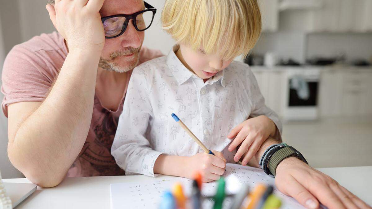 Tired father helping school boy with ADHD do his homework at home. Homeschooling, distance learning, online studying, remote education for kids. Dad involving in raising of child. Parent burnout. home-school home school homeschool