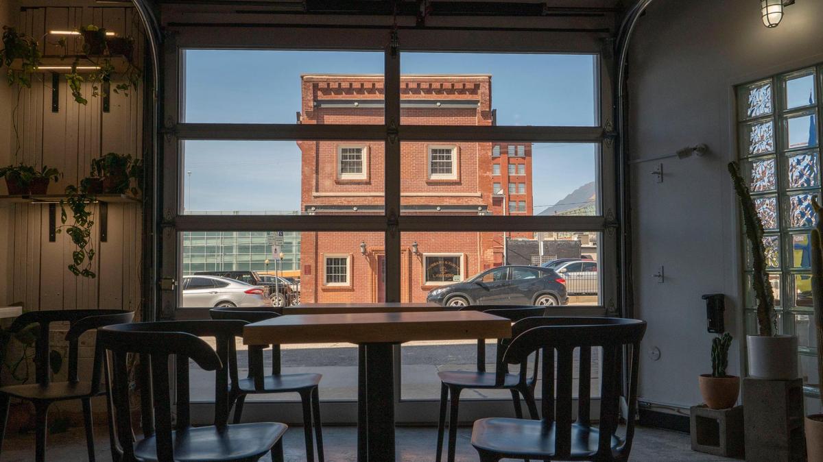 A garage door and house plants adorn the inside of The Slow Bar in the Crossroads.