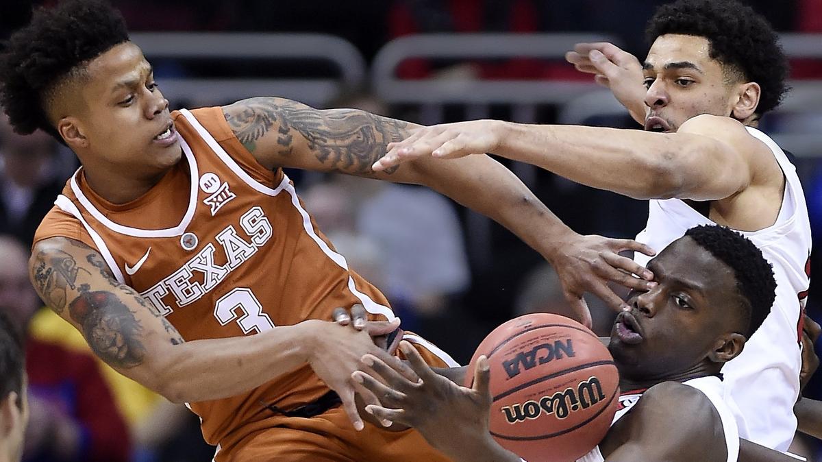 Texas' Jacob Young (left), who scored 29 points, inadvertently poked Texas Tech's Norense Odiase in the eye as they battled for a rebound in the first half of Thursday night's Big 12 Tournament game at the Sprint Center.
