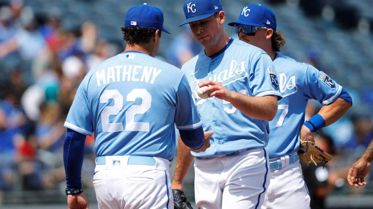 Kansas City Royals starting pitcher Kris Bubic, center, hands the ball to manager Mike Matheny (22) after he is taken out after loading the bases during the first inning of a baseball game against the Cleveland Guardians in Kansas City, Mo., Sunday, April 10, 2022. (AP Photo/Colin E. Braley)