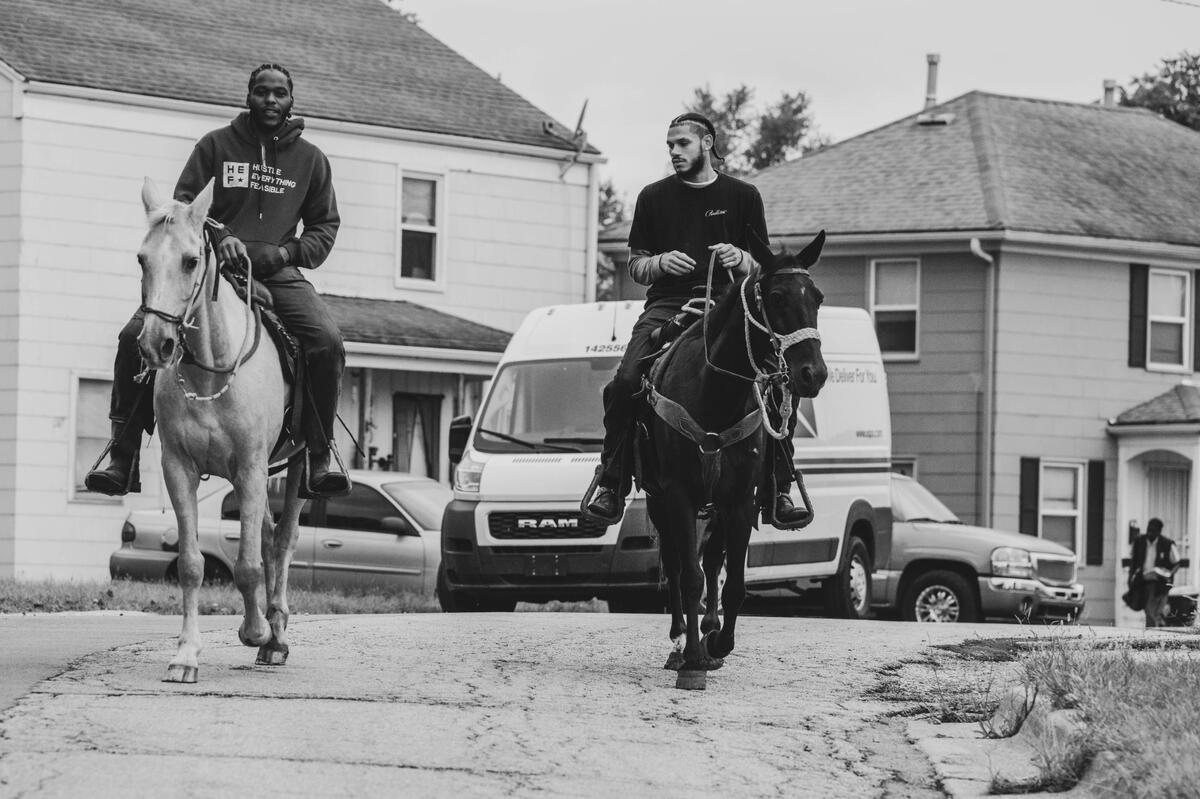 CB Otto and CB Zay ride through a neighborhood during a community outreach ride with KCPD in Kansas City. The Copper Boyz use horses as a way of outreach partnered with the police. The police appreciate what the Copper Boyz bring to the table, acknowledging that it helps bridge the gap between the people and law enforcement.