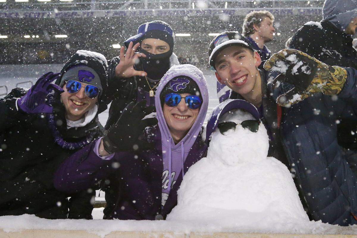 Kansas State Wildcats fans pose with a snowman before the start of a game against the Iowa State Cyclones at Bill Snyder Family Football Stadium on Nov. 25, 2023.