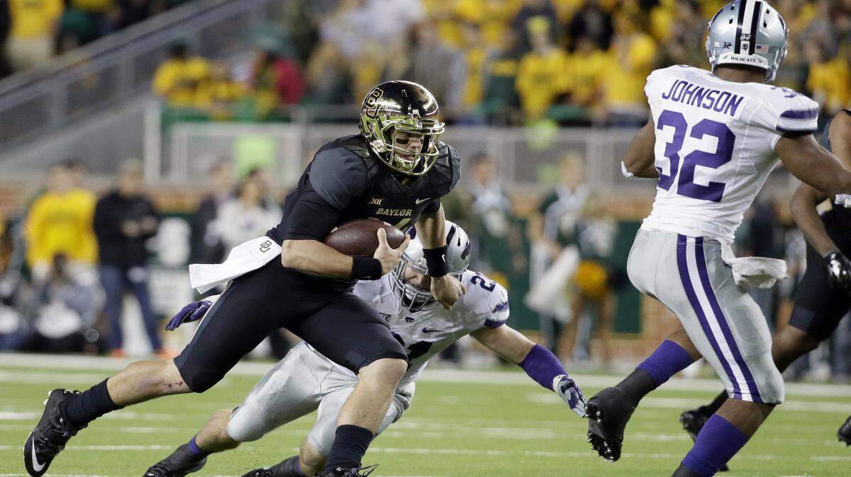 Baylor quarterback Bryce Petty, left, finds running room on a play as Kansas State's Jonathan Truman (21) and Dakorey Johnson (32) defend in the first half of an NCAA college football game, Saturday, Dec. 6, 2014, in Waco, Texas. 