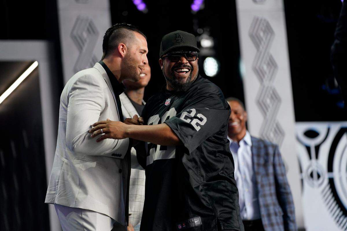 Entertainer Ice Cube, right, hugs Raiders quarterback Derek Carr before the 2022 NFL Draft gets underway Thursday evening in Las Vegas.