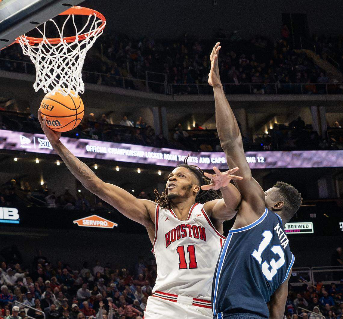 Houston Cougars forward Joseph Tugler (11) makes a layup over BYU Cougars center Keba Keita (13) during the second half of a Big 12 Men's Basketball Tournament game at T-Mobile Center on Thursday, March 12, 2026, in Kansas City.