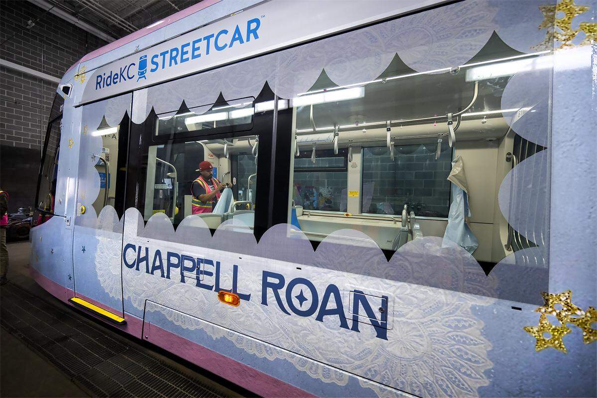 Marcos Medrano works to peel the backing from a large vinyl decal being installed on a seat inside a KC Streetcar that was being wrapped in a Chappell Roan motif on Thursday, Sept. 25, 2025, at the Singleton Yard Maintenance Facility in Kansas City. The singer will perform two concerts in October in Kansas City.