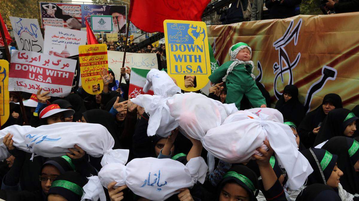 Iranian women and children carry placards and dummies outside the former U.S. embassy in Tehran on Nov. 4, 2015, during a demonstration marking the anniversary of its storming by student protesters that triggered a hostage crisis in 1979. 
