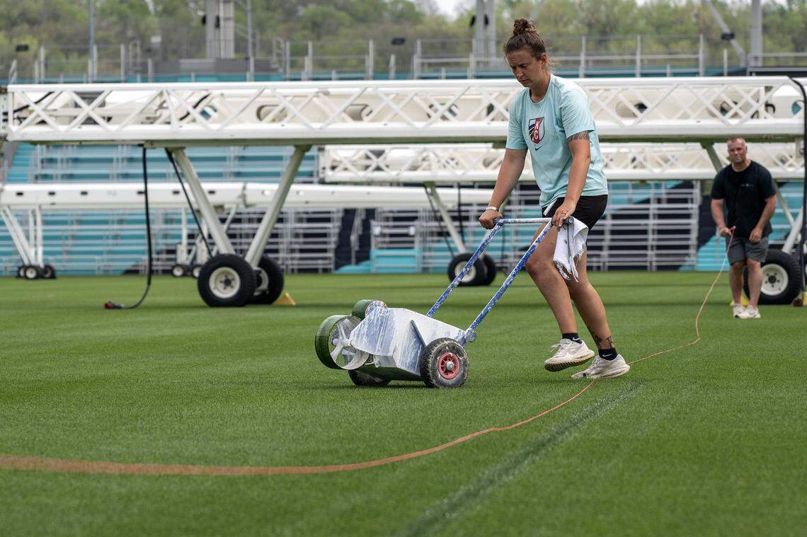 Trina Strayer, Kansas City Current grounds-crew member, operates a line-marking machine guided by a string line to cover existing pitch lines in preparation for rugby at CPKC Stadium on Tuesday, April 14, 2026, in Kansas City.