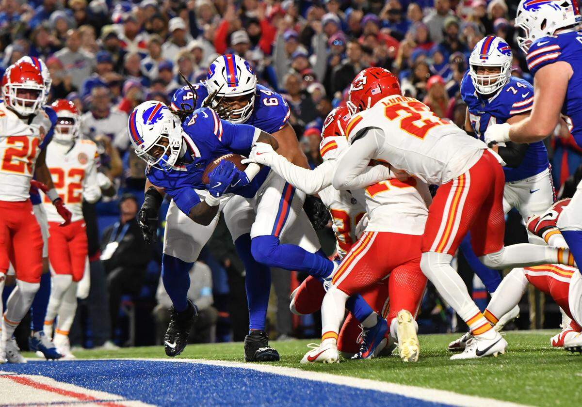 Buffalo Bills running back James Cook (4) scores a touchdown against the Kansas City Chiefs in the second quarter at Highmark Stadium.
