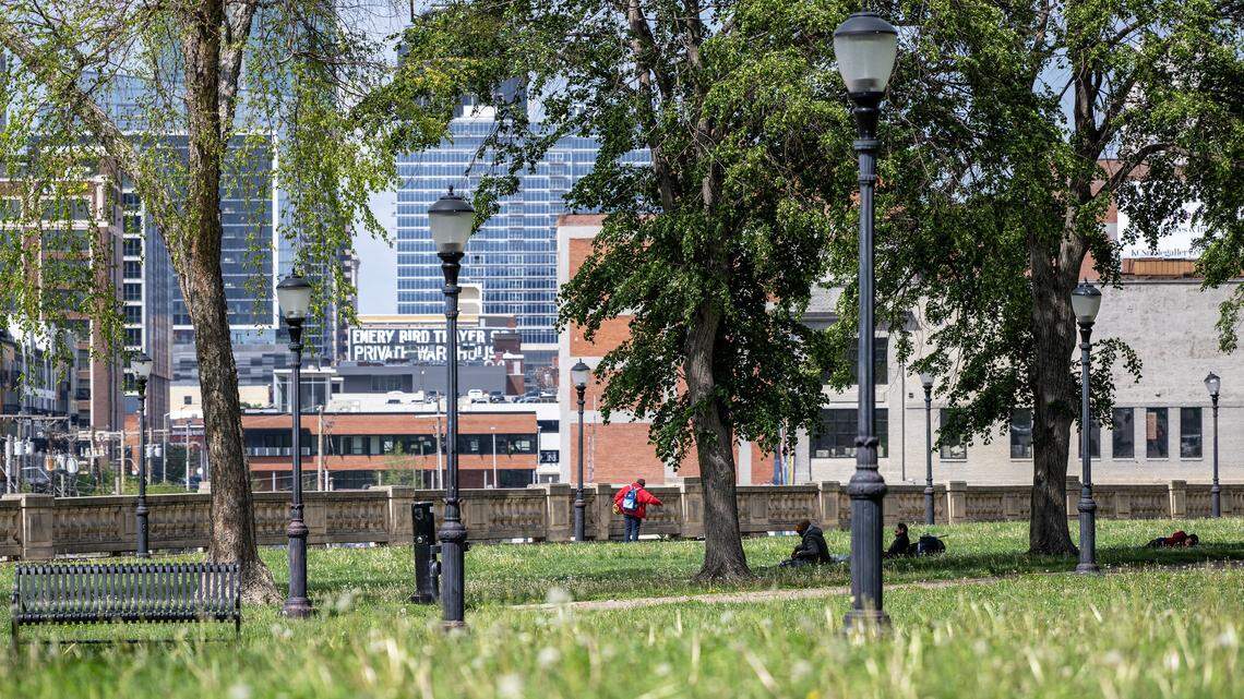People lay on the grass at Washington Square Park on Wednesday, April 15, 2026, in Kansas City.