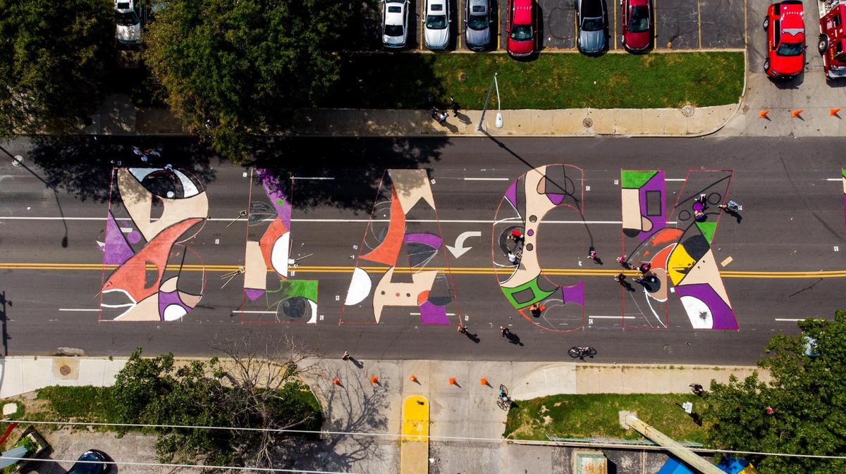 Artists and volunteers work on a giant Black Lives Matter mural at 63rd St. and Troost Ave. Saturday, Sep. 5, 2020. Six unique Black Lives Matter murals were painted at the same time across the Kansas City.
