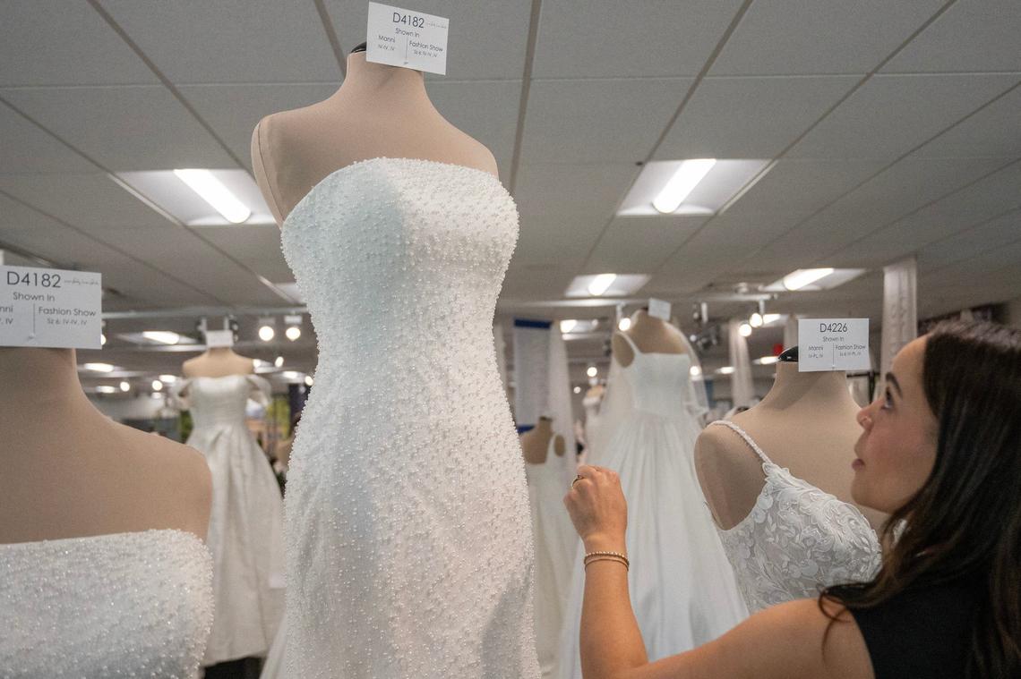 A customer observes looks at a bridal dress adorned with embroidered pearls on Monday, Aug. 5, 2024, in Lenexa.