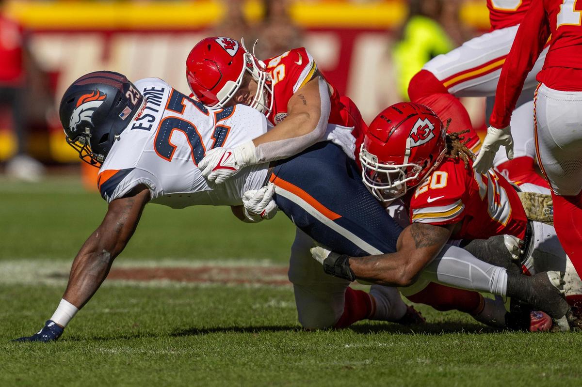 Kansas City Chiefs defensive end George Karlaftis (56) and safety Justin Reid (20) tackle Denver Broncos running back Audric Estime (23) in the first quarter during and NFL game on Sunday, Nov. 10, 2024, at GEHA Field at Arrowhead Stadium.