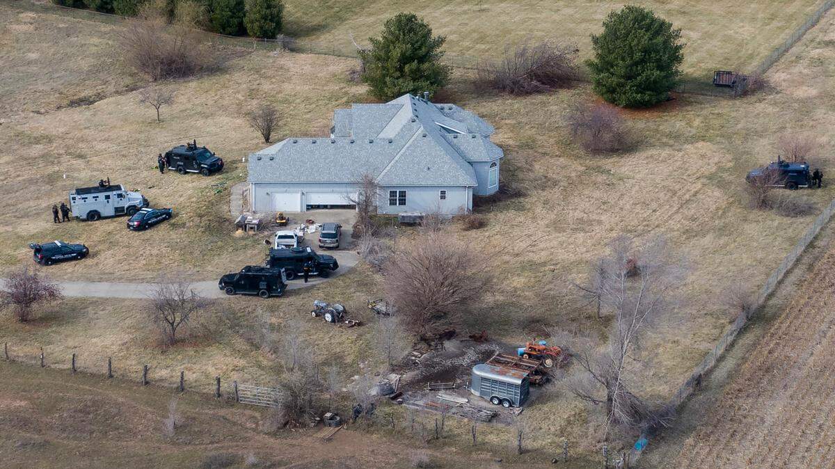 Tactical police vehicles were outside of the house at 1111 N. Else Smith Road where police say a suspect opened fire and killed a Jackson County civil process server and an Independence police officer on Thursday. Two other officers were injured in the shooting.