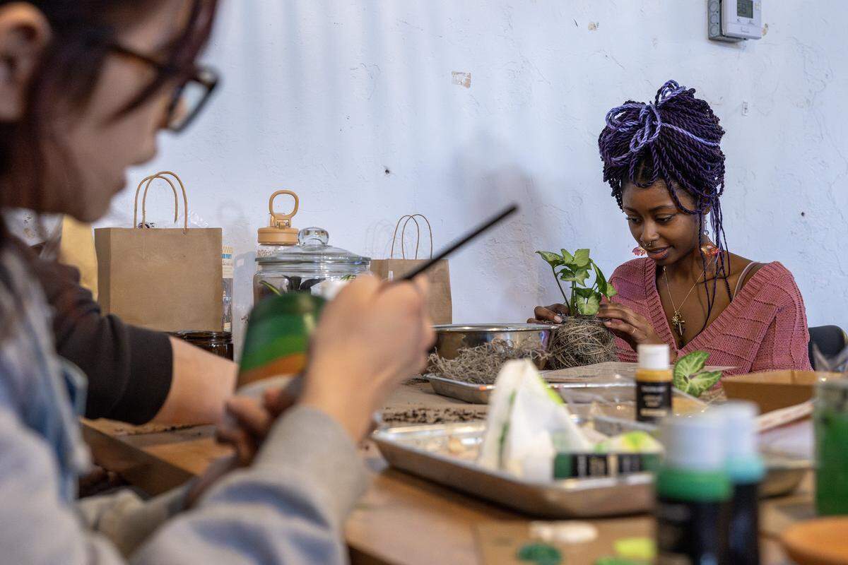 Liv Burnett wraps an air plant with moss and twine while making a planter at ADHDIY Craft Cafe on Saturday, Feb. 7, 2026, in Kansas City.