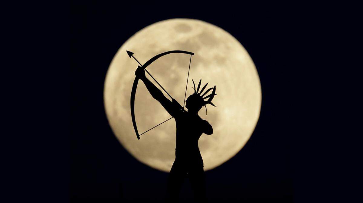 A full moon rises behind a statue of a Kansas Indian on top of the Kansas Statehouse in this 2013 file photo.