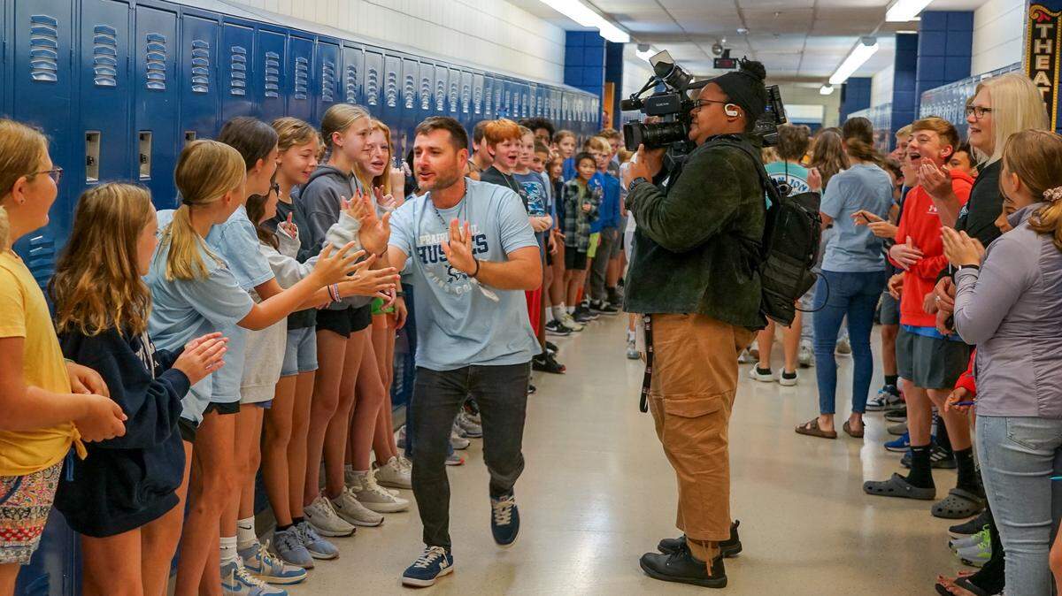 Prairie Trail Middle School students and staff cheer on Taylor Bussinger, an eighth grade social studies teacher, to celebrate him being named the 2024 Kansas Teacher of the Year.